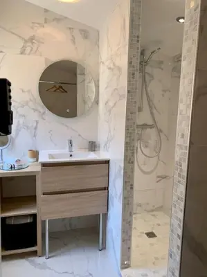 a bathroom with a sink and a shower with a mirror at Maisonnette atypique cadarache-iter in Saint-Paul-lez-Durance