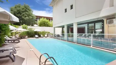 a swimming pool in front of a building at Ma place au sud Aix Parking in Aix-en-Provence