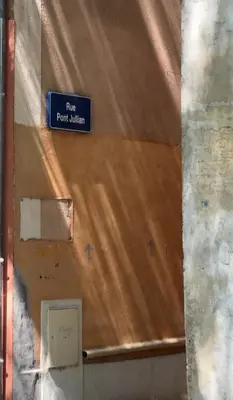 a blue sign on the top of a wall at Studio3 proche Quai Rouget in LʼIsle-sur-la-Sorgue