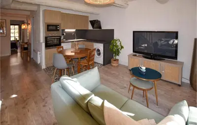 a living room with a couch and a tv and a table at Awesome Apartment In Rustrel in Rustrel