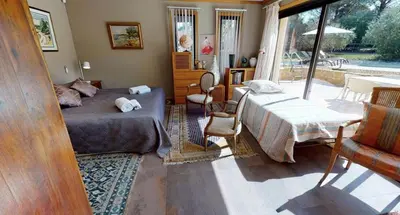 a bedroom with a bed and a large window at Sérénité en Provence, Climatisée in La Roque-sur-Pernes