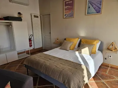 a bedroom with a bed and a flat screen tv at Gîte Le Refuge in Monieux