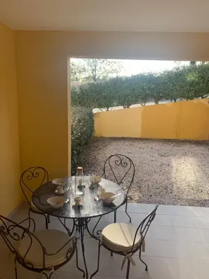 a table and chairs in a room with a window at la pinède in Roussillon