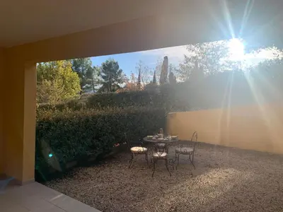 a patio with a table and chairs in a backyard at la pinède in Roussillon