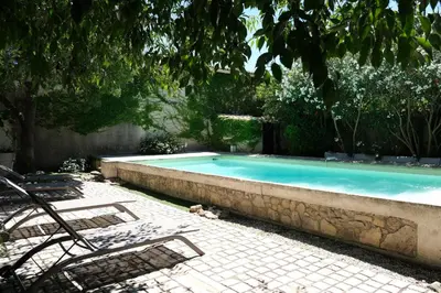 a swimming pool with two lounge chairs next to it at charming provencal house with private pool for 4 people in cheval blanc, luberon. in Cheval-Blanc