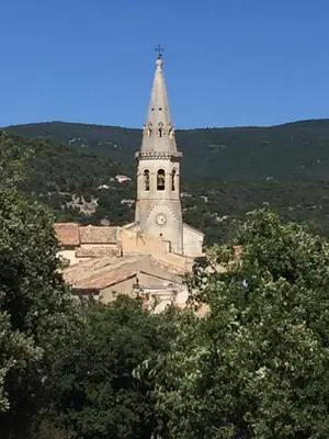 a church with a tower with a clock on it at lagalerie84 in Saint-Saturnin-les-Apt