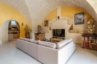 a living room with a couch and a tv at Errances Provençales in Saint-Rémy-de-Provence
