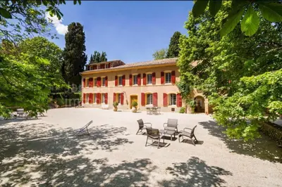 a large building with chairs in front of it at Suite le Quervalat dans magnifique bastide 18eme in Aix-en-Provence