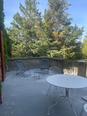 a patio with two tables and chairs and trees at Suite le Quervalat dans magnifique bastide 18eme in Aix-en-Provence