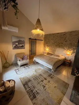 a bedroom with a bed and a chandelier at Le Mazet de l'Isle sur la Sorgue in Saumane-de-Vaucluse