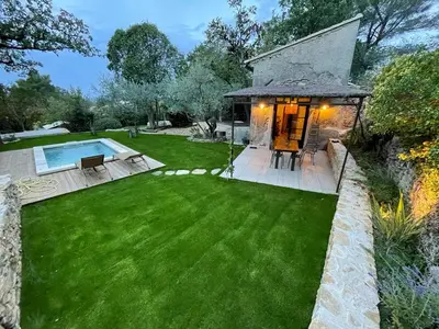 a garden with a swimming pool and a house at Le Mazet de l'Isle sur la Sorgue in Saumane-de-Vaucluse