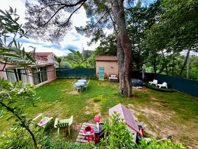 a backyard with a table and chairs and a tree at Aix-en-Provence, Maison provençale au calme de la campagne avec Jacuzzi in Aix-en-Provence