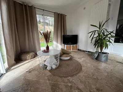 a living room with a table and potted plants at Aix-en-Provence, Maison provençale au calme de la campagne avec Jacuzzi in Aix-en-Provence