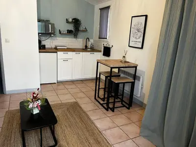 a kitchen with a table and chairs in a room at Aix-en-Provence, Charmant studio proche toutes comodités et axes routiers, linges fournis in Aix-en-Provence