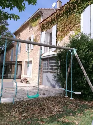 an empty swing set in front of a house at Maison de 6 chambres avec piscine privée, jardin aménagé et wifi à Pernes-les-Fontaines in Pernes-les-Fontaines
