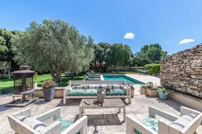 a patio with chairs and a pool in a yard at magnificent individual villa with heated swimming pool, in aureille, in the alpilles - 10 persons in Aureille