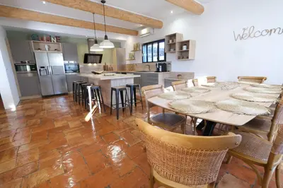 a dining room with tables and chairs and a kitchen at magnificent individual villa with heated swimming pool, in aureille, in the alpilles - 10 persons in Aureille