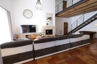 a living room with a large couch and a fireplace at magnificent individual villa with heated swimming pool, in aureille, in the alpilles - 10 persons in Aureille