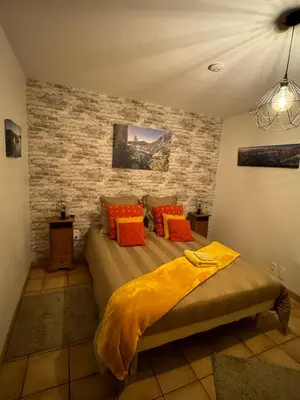 a bedroom with a bed with orange pillows at Gîte Le Sirocco Meublé de tourisme 4 étoiles Le Moulin de Prédelles in Reillanne