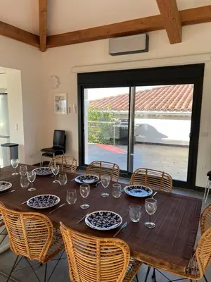 a wooden table with chairs and glasses on it at Villa Design in Bédoin