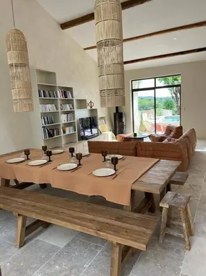 a living room with a large wooden table with benches at La Planette in Venasque