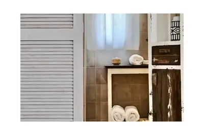 a kitchen with a window and a shelf with towels at Les Jardins de Sitaara in Cucuron