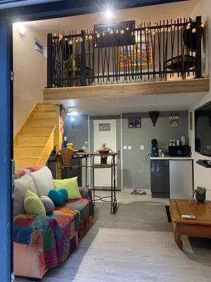 a living room with a couch and a staircase at Standing duplex FULL Equipements idéal moyen séjours in Le Thor