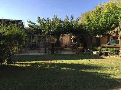 a house with a yard with trees and a fence at Standing duplex FULL Equipements idéal moyen séjours in Le Thor