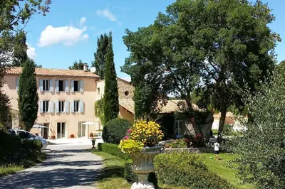 a house with a vase of flowers in a yard at Gîte Le Nathalie Meublé de tourisme 4 étoiles Le Moulin de Prédelles in Reillanne