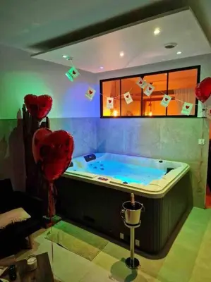 a room with a hot tub with two heart balloons at Appartement - Spa in Monteux
