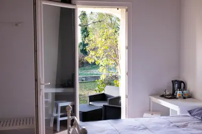 a bedroom with a door open to a patio at La Halte Gourmande in Vachères
