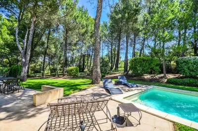 a backyard with a pool and chairs and a table at Les Mas et Villas de Pont Royal en Provence - maeva Home - Villa 5 Pièces 8 Personnes avec piscine privée et vue sur le golf - Exclusive - super Home MAE-6074 in Mallemort