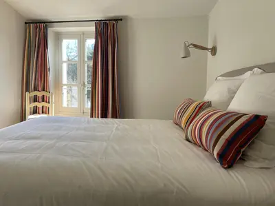 a white bed with a pillow on it with a window at VENTOUX in Apt