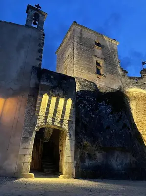 an old stone building with a tower with a door at LES ROCHES in Apt