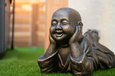 a statue of a black girl sitting on the grass at Lovina chambre de charme avec jacuzzi in Velaux