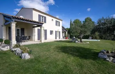 a large white house with a yard with grass at La marinette in Fontaine-de-Vaucluse