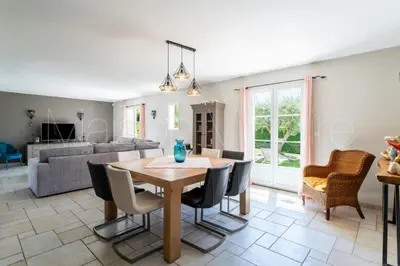 a dining room and living room with a table and chairs at La marinette in Fontaine-de-Vaucluse