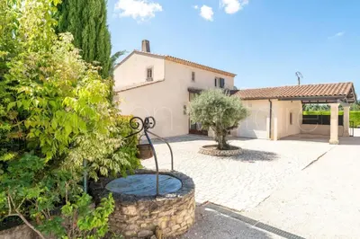 an exterior view of a house with a statue in a courtyard at La marinette in Fontaine-de-Vaucluse
