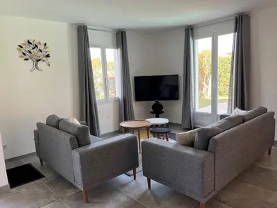 a living room with two couches and a tv at Golf de Pont Royal Villa des Alpilles climatisée 3 chambres Piscine chauffée Parking et Garage in Mallemort