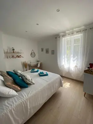 a bedroom with a large white bed with blue pillows at Chambre d'hôtes Zephyr Libeccio Le Moulin de Prédelles in Reillanne
