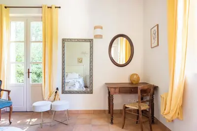 a room with a mirror and a table and chair at Mas de Lure in Salon-de-Provence