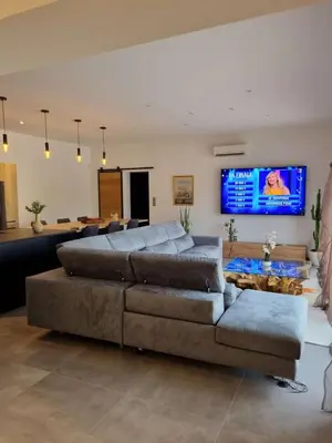 a living room with a large couch and a flat screen tv at Villa contemporaine in Pernes-les-Fontaines