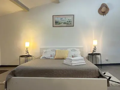 a bedroom with a bed with two lamps on it at Maison avec piscine - Luberon in Saint-Saturnin-les-Apt