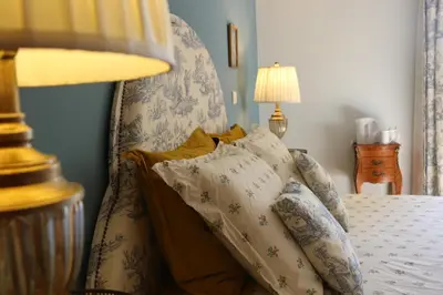 a bedroom with a bed with pillows and a lamp at Les Chambres de Fanny in Cabrières-dʼAigues