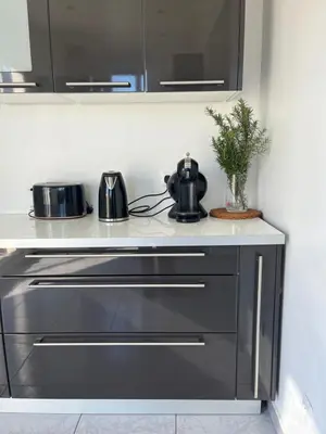 a kitchen counter with a stove and a tea pot at Villa climatisé avec piscine et jacuzzi in Carpentras