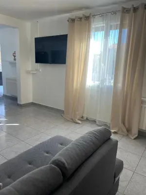 a living room with a couch and a television at Villa climatisé avec piscine et jacuzzi in Carpentras