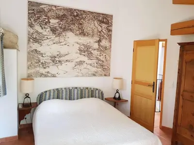 a bedroom with a bed and a painting on the wall at Maison de caractère dans Luberon avec piscine in Saignon