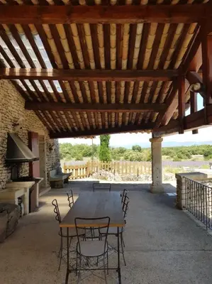 a wooden table and chairs under a wooden roof at Maison de caractère dans Luberon avec piscine in Saignon