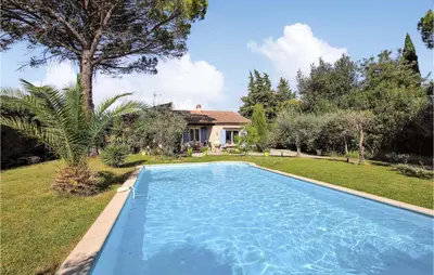 a swimming pool in a yard with a house at Lovely Home In Cheval-Blanc in Cheval-Blanc