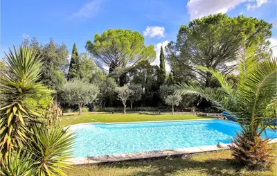 a swimming pool in a garden with trees at Lovely Home In Cheval-Blanc in Cheval-Blanc